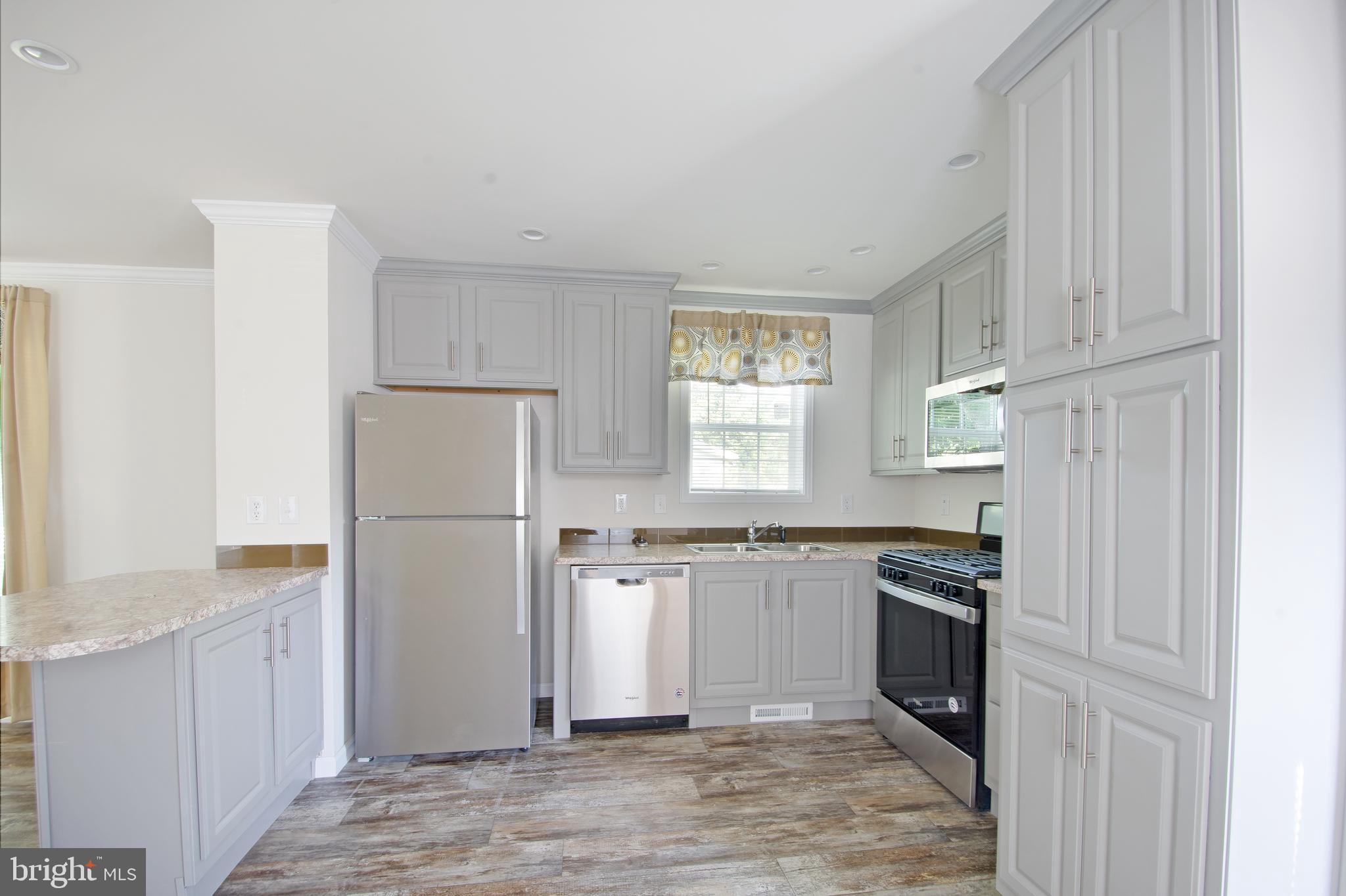1679 South State Street, Unit A57 Dover, DE 19901 - Photo 10 of 25 a kitchen with granite countertop a refrigerator stove top oven and sink