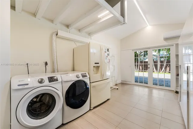 a view of washer and dryer with bathroom in the background