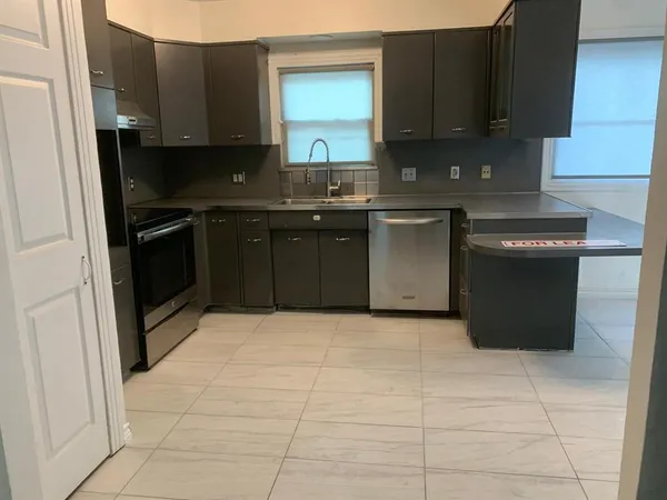 a kitchen with a sink a stove and cabinets