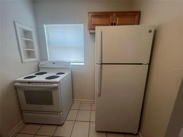 a white refrigerator freezer and a stove sitting inside of a kitchen