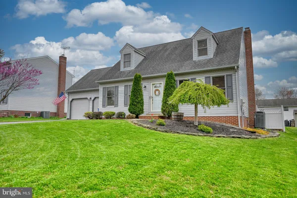 a front view of a house with a yard and green space