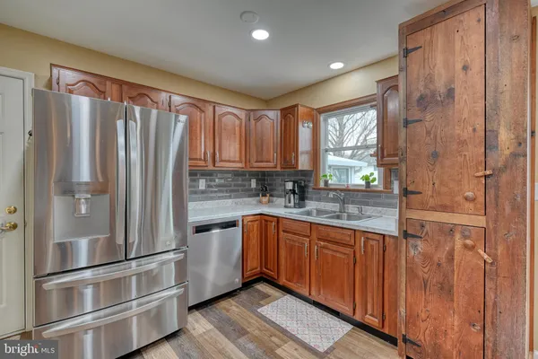 a kitchen with stainless steel appliances granite countertop a refrigerator and a sink