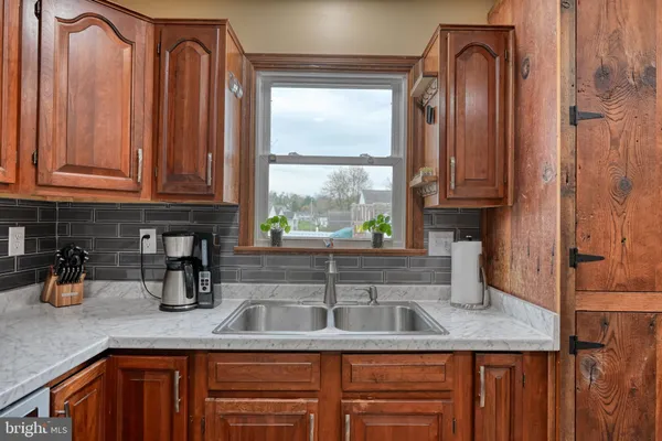 a kitchen with granite countertop a sink a window and cabinets
