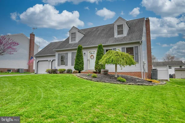 a front view of a house with a yard and green space