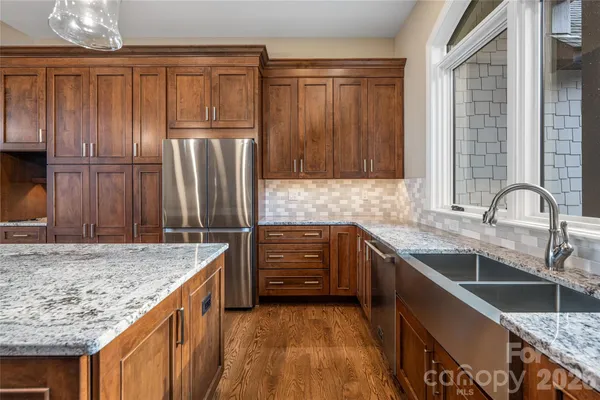 a kitchen with granite countertop a sink and refrigerator