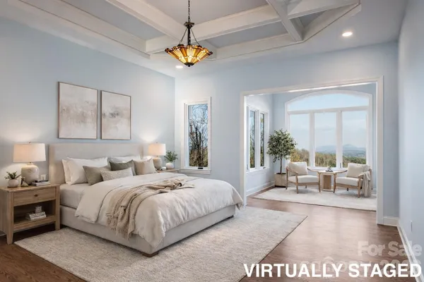 a bedroom with a large bed and a chandelier