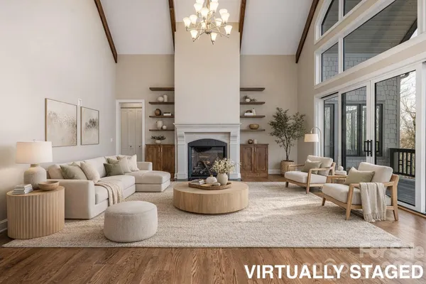 a living room with furniture a chandelier and a fireplace