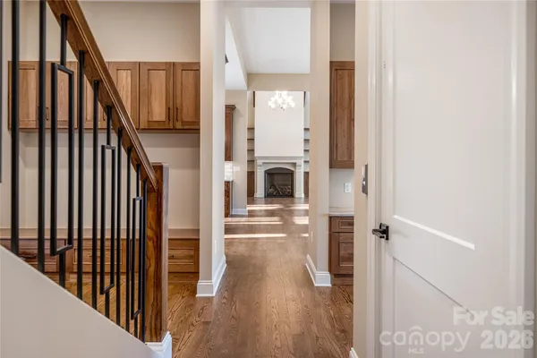 a view of a hallway with wooden floor and staircase
