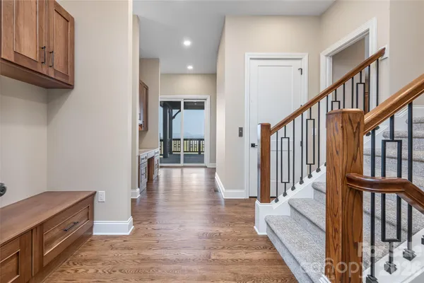a view of a hallway with wooden floor and staircase