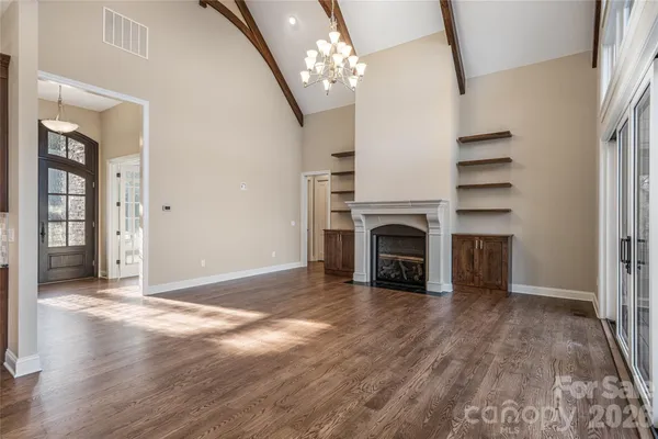 a view of a livingroom with a fireplace a chandelier and stairs
