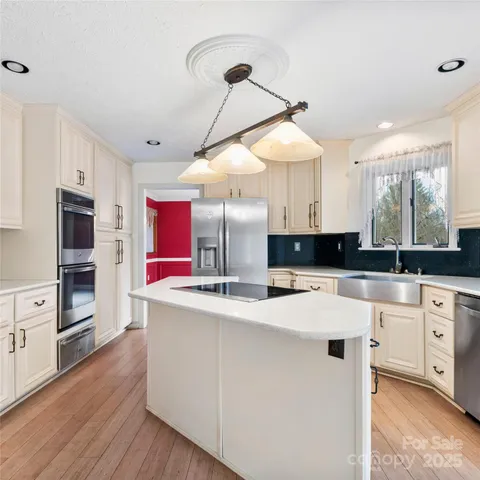 a kitchen with stainless steel appliances granite countertop a sink a stove and a refrigerator