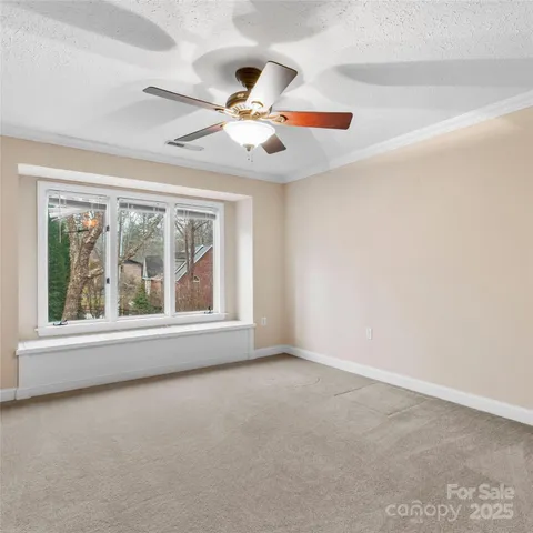 an empty room with windows and fan