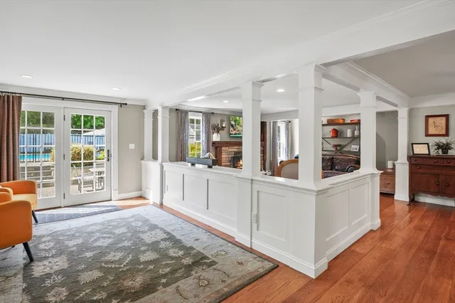 a large white room with wooden floor and furniture