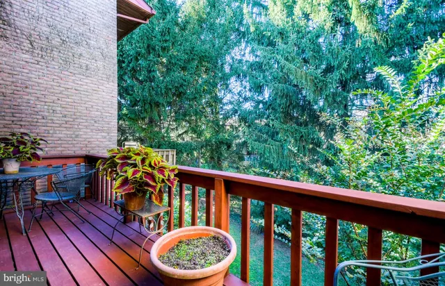 a balcony with wooden floor and outdoor seating