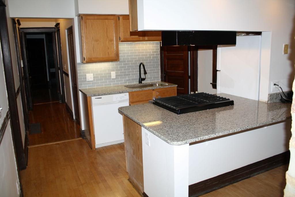 3018 North Racine Avenue, Unit 3F Chicago, IL 60657 - Photo 2 of 10 a kitchen with granite countertop a sink stainless steel appliances and cabinets