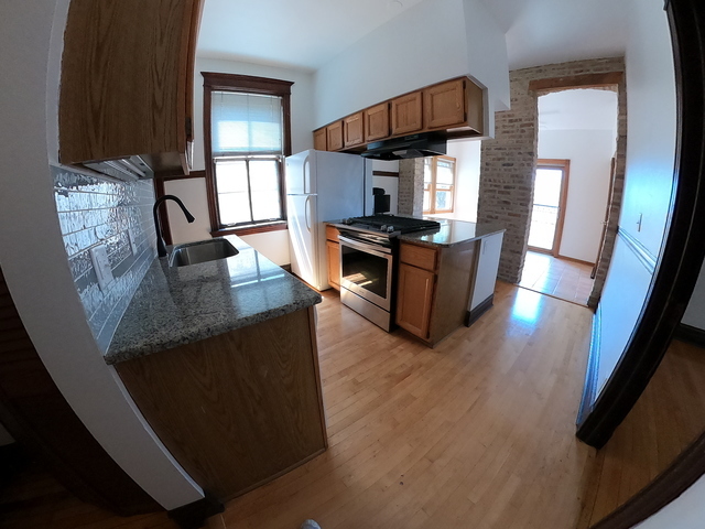3018 North Racine Avenue, Unit 3F Chicago, IL 60657 - Photo 4 of 10 a kitchen with stainless steel appliances granite countertop a sink stove and refrigerator