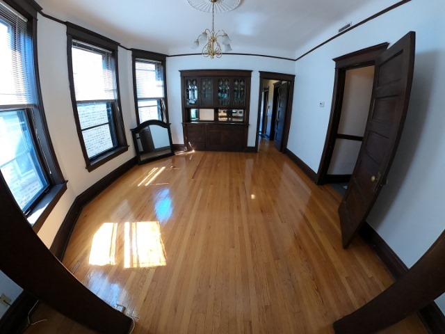 3018 North Racine Avenue, Unit 3F Chicago, IL 60657 - Photo 6 of 10 wooden floor in an empty room with a window
