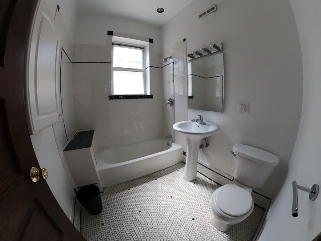 3018 North Racine Avenue, Unit 3F Chicago, IL 60657 - Photo 9 of 10 a bathroom with a toilet sink and mirror