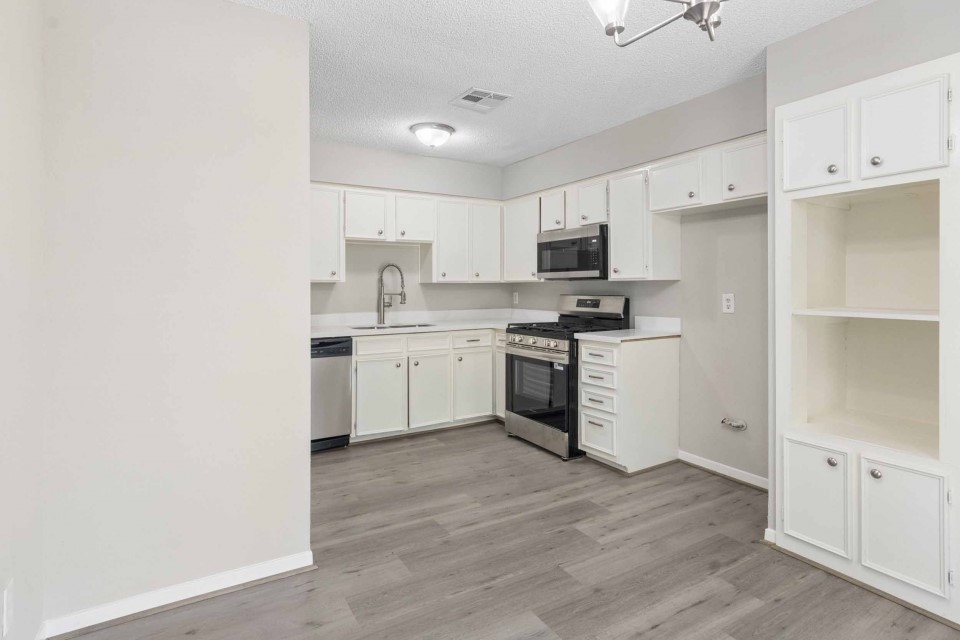 7403 Strawbridge Lane Houston, TX 77040 - Photo 7 of 22 a kitchen with white cabinets and white appliances