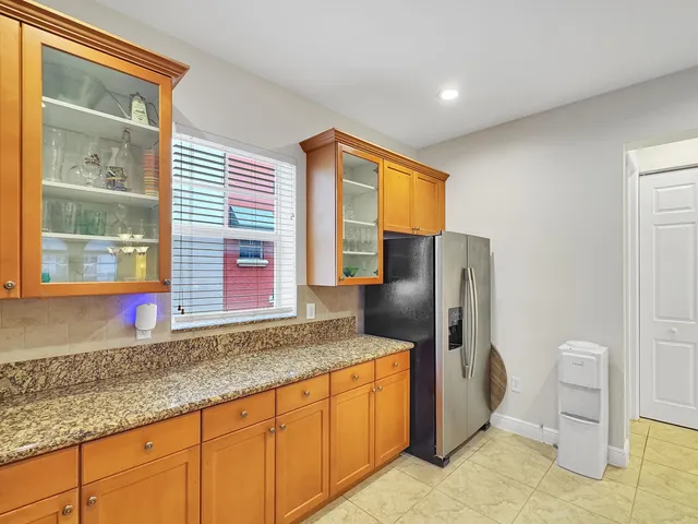 a kitchen with stainless steel appliances granite countertop a refrigerator and a sink