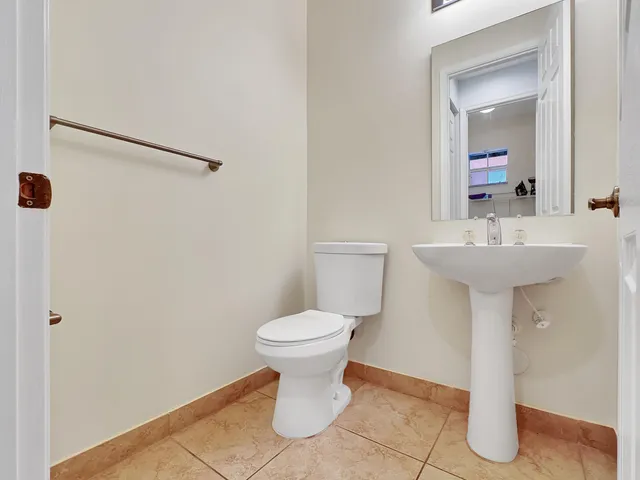 a bathroom with a sink toilet and a mirror