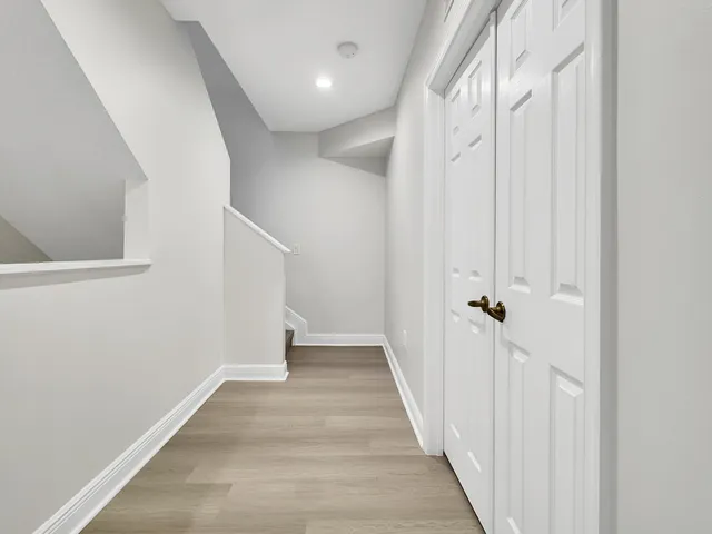 a view of a hallway with wooden floor and staircase