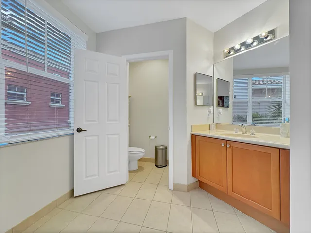 a spacious bathroom with a granite countertop sink a mirror and a bathtub