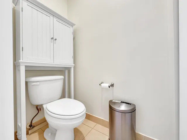 a white toilet sitting next to a white cabinet