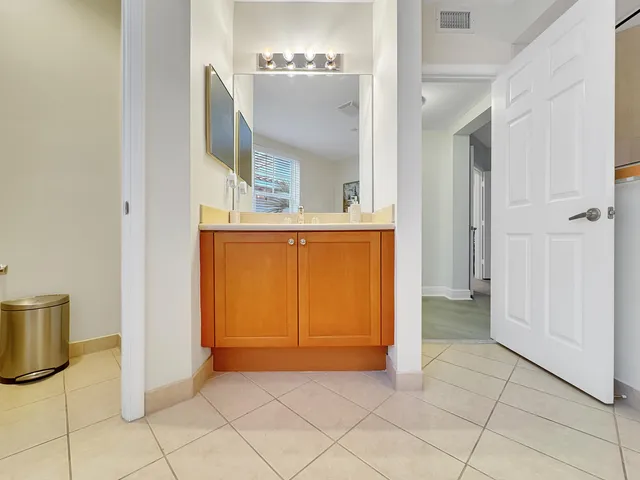 a view of a room that has a mirror and cabinets