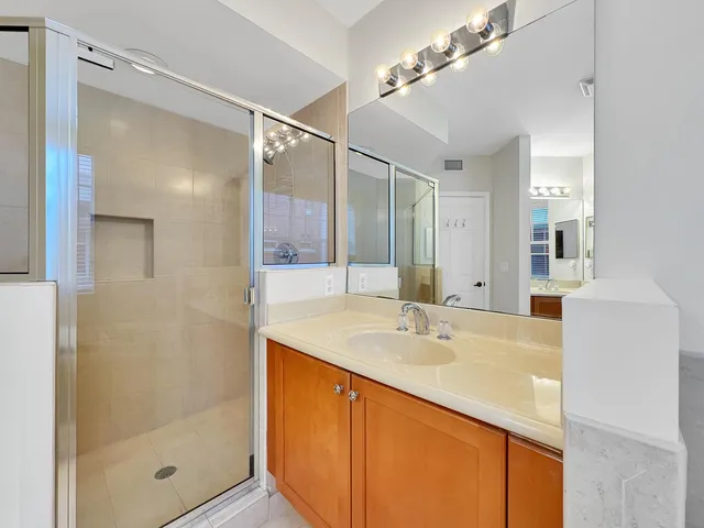 a bathroom with a sink mirror and shower