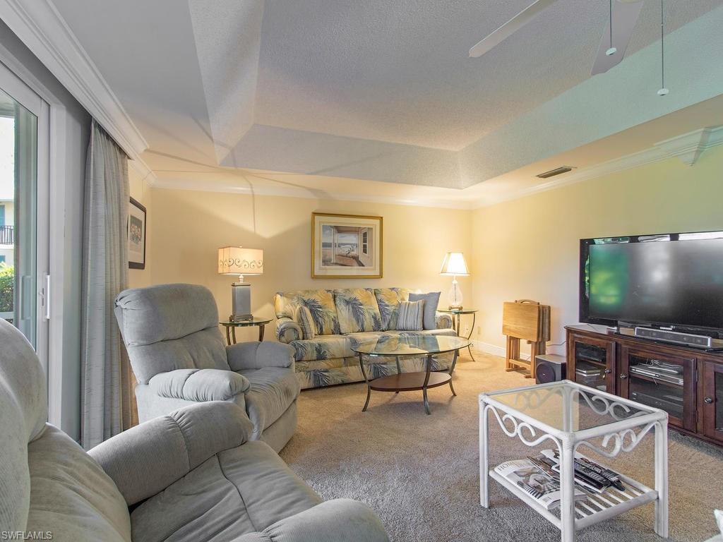 213 Quails Nest Road, Unit 1 Naples, FL 34112 - Photo 3 of 11 a living room with furniture and a flat screen tv