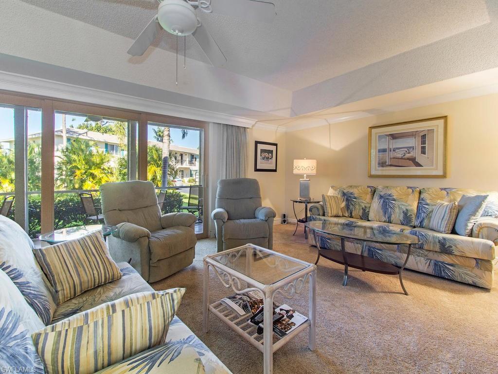 213 Quails Nest Road, Unit 1 Naples, FL 34112 - Photo 4 of 11 a living room with furniture a rug and a large window