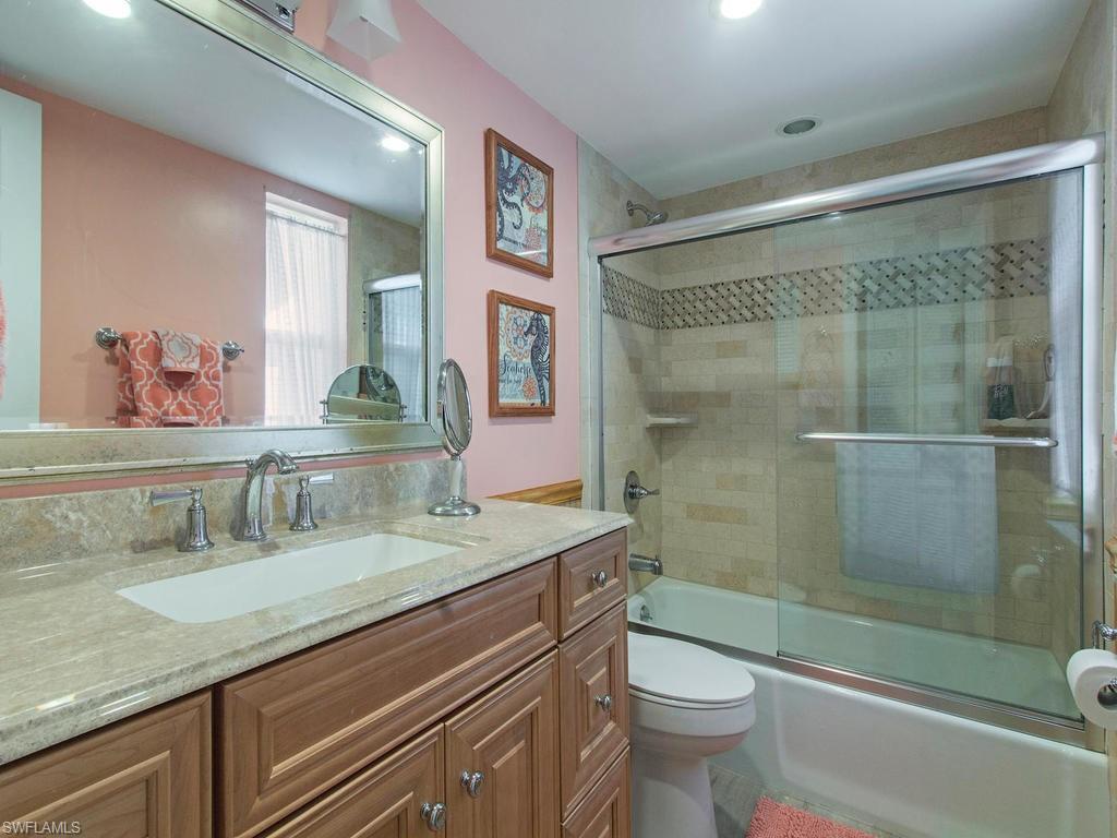 213 Quails Nest Road, Unit 1 Naples, FL 34112 - Photo 8 of 11 a bathroom with a granite countertop sink toilet and shower