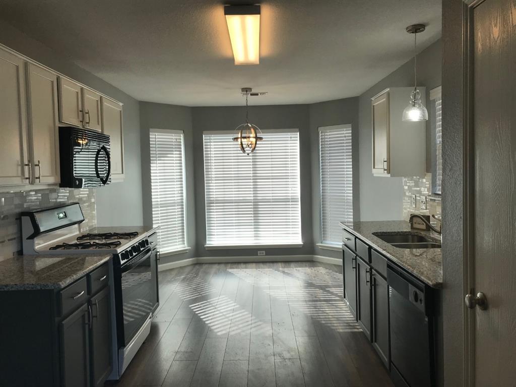 3305 Rustic Meadow Trail Mansfield, TX 76063 - Photo 6 of 12 Kitchen featuring wood-finish flooring, granite countertops, and a tile backsplash