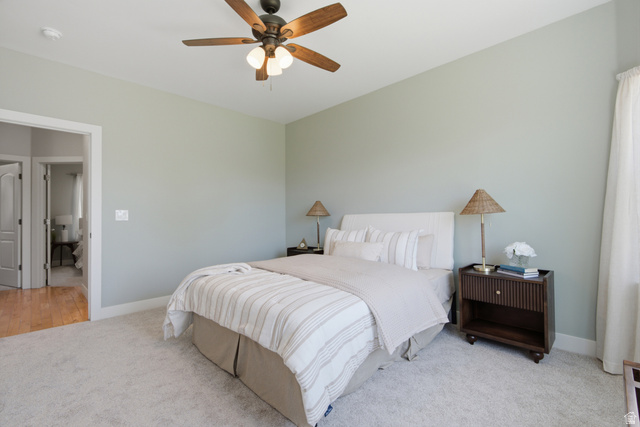 1252 Skyline Road Saratoga Springs, UT 84045 - Photo 18 of 51 Carpeted bedroom featuring a ceiling fan with light kit, light-colored walls, and an open doorway revealing wood-finish flooring in an adjoining space