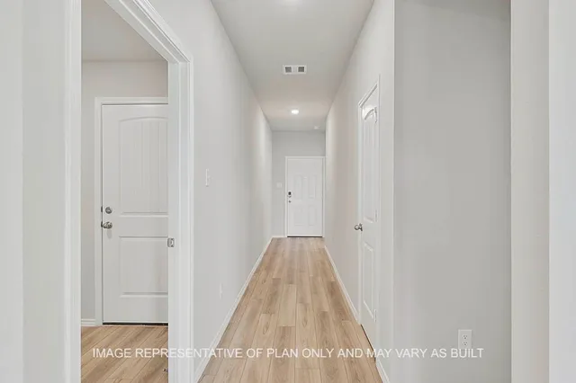 a view of a hallway with wooden floor and entryway