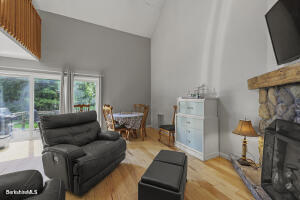 1052 Beaver Pond Road Williamstown, MA 01267 - Photo 11 of 37 a living room with furniture a flat screen tv and a fireplace