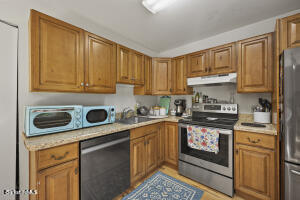 1052 Beaver Pond Road Williamstown, MA 01267 - Photo 8 of 37 a kitchen with stainless steel appliances granite countertop a stove a sink and a microwave