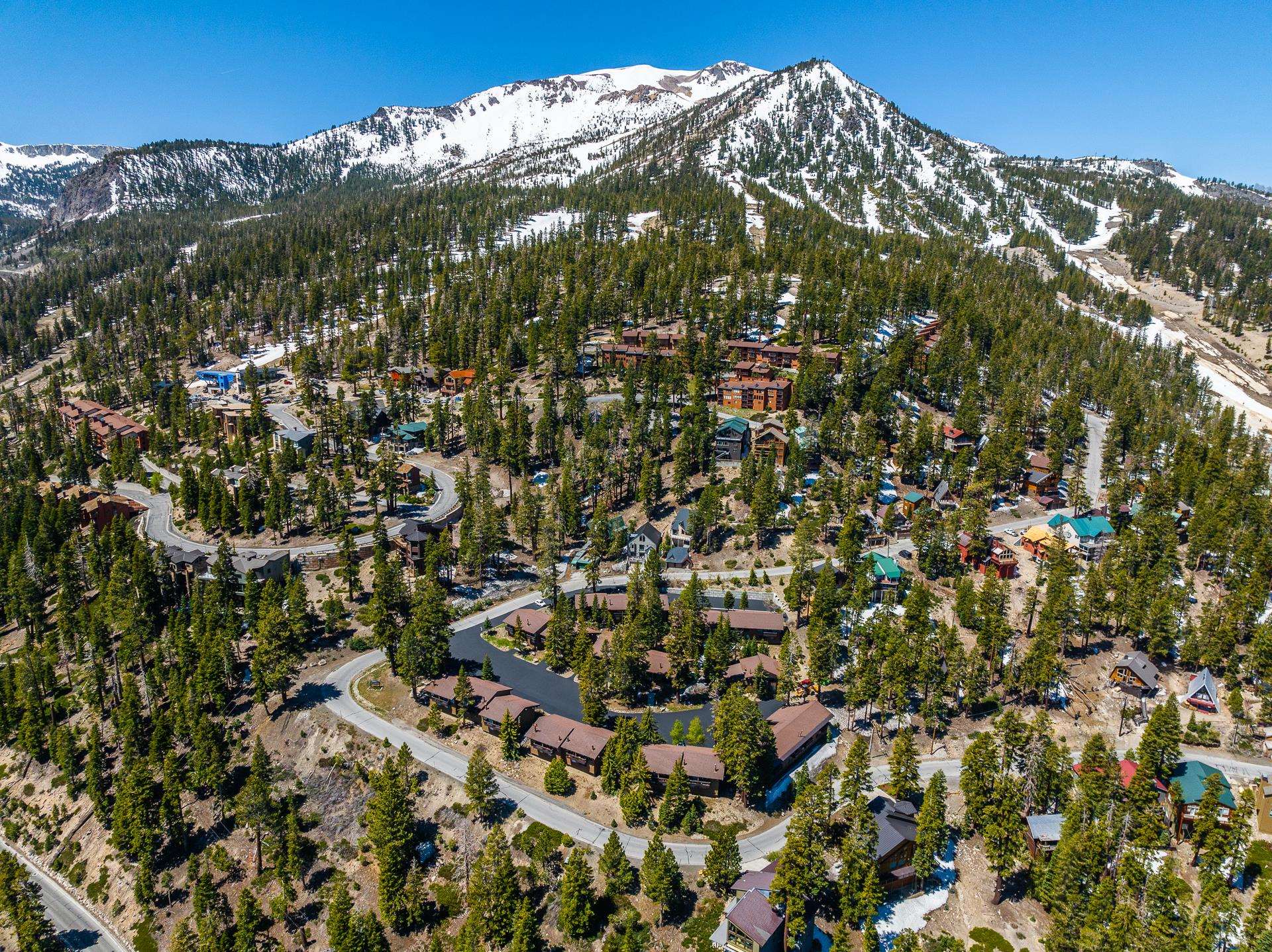 94 John Muir Road, Unit 132 Mammoth Lakes, CA 93546 - Photo 52 of 58 Mountain community featuring snow-capped peaks, dense evergreen forests, winding paved roads, and scattered residential structures