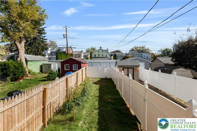 a view of a house with a small yard and deck