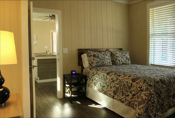 a bedroom with a bed and wooden floor