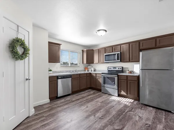 a large kitchen with a refrigerator stove microwave and sink