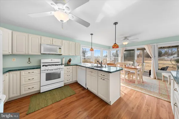 a kitchen with stainless steel appliances white cabinets and wooden floor
