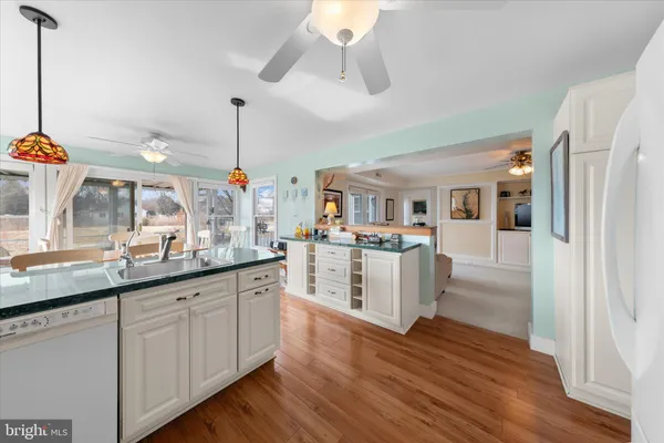 a kitchen with white cabinets and sink