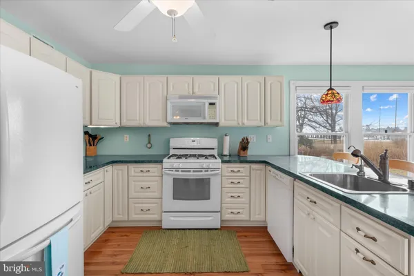 a kitchen with a white cabinets sink and stove