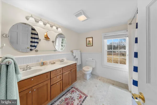 a spacious bathroom with a toilet sink and mirror