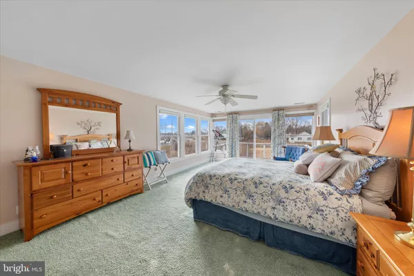 a bedroom with a bed and large windows