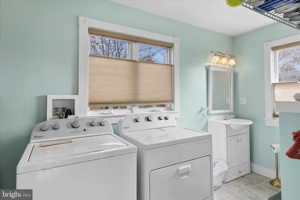 a view of washer and dryer with bathroom in the background
