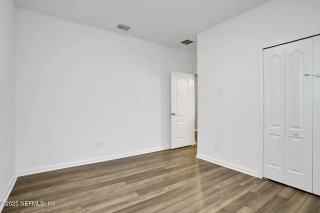a view of an empty room with wooden floor