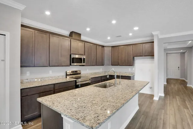 a kitchen with stainless steel appliances granite countertop wooden cabinets a sink and dishwasher